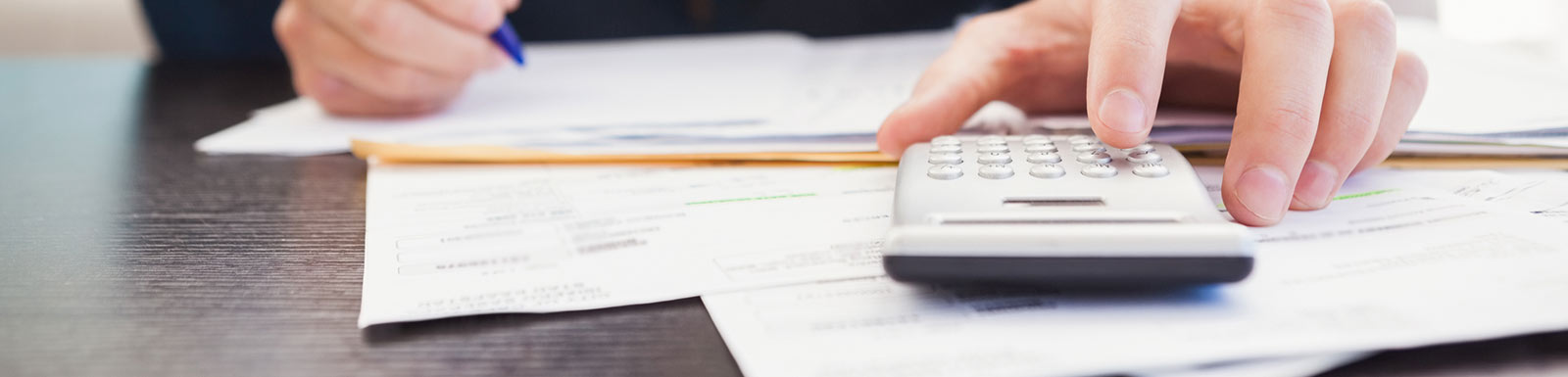 Man using calculator with papers